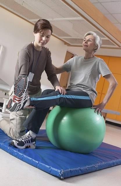 Orlando PTA helping elderly patient regain mobility on exercise ball